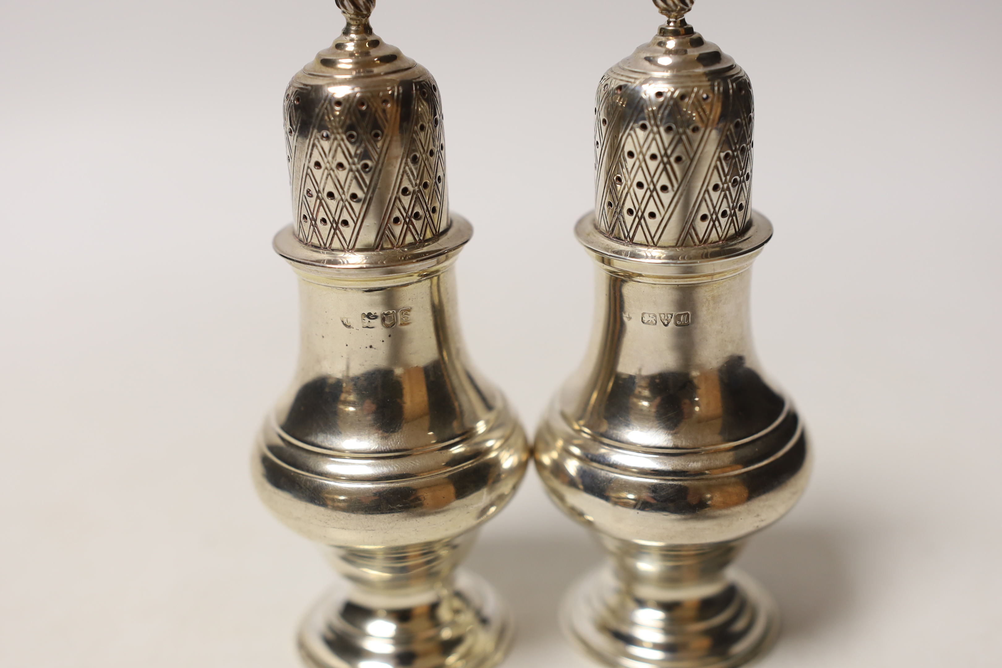 A matched pair of George V silver pepperettes, Chester 1912 and London, 1913, 12.3cm, 4.3oz.